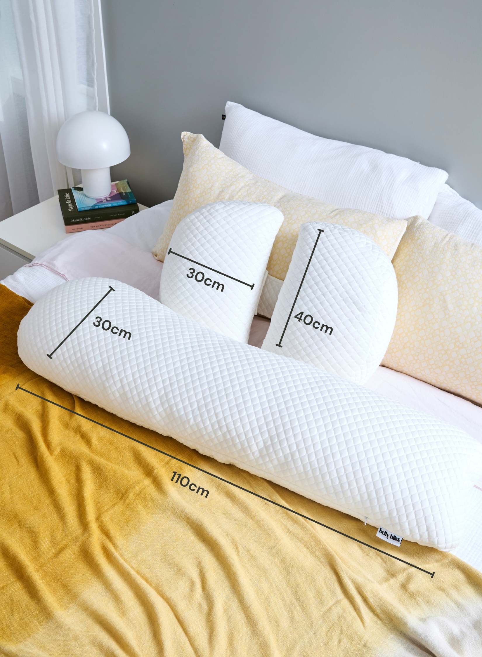 White pillow with measurements on a bed in a bedroom setting