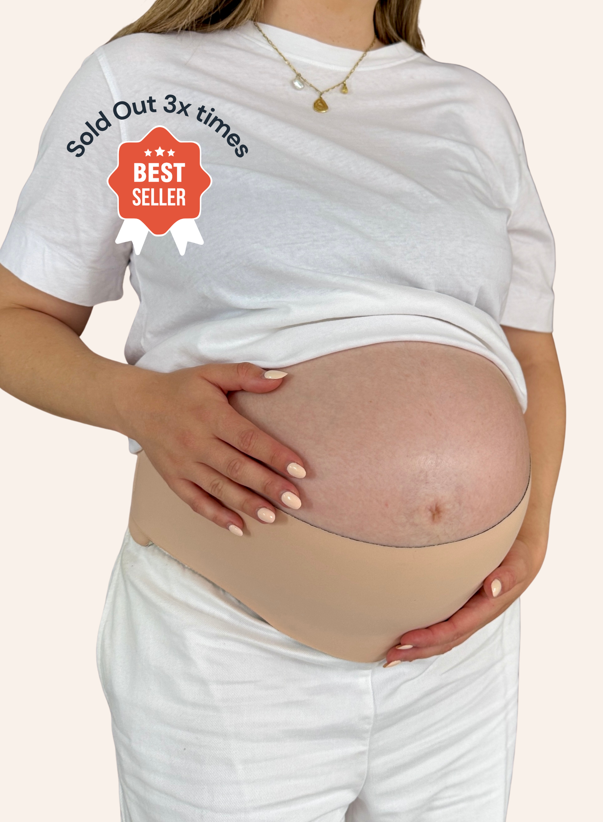 A pregnant model wearing a beige maternity belly band over a white t-shirt and white pants, holding her baby bump. The image features a red 'Best Seller' badge overlay on the left chest.