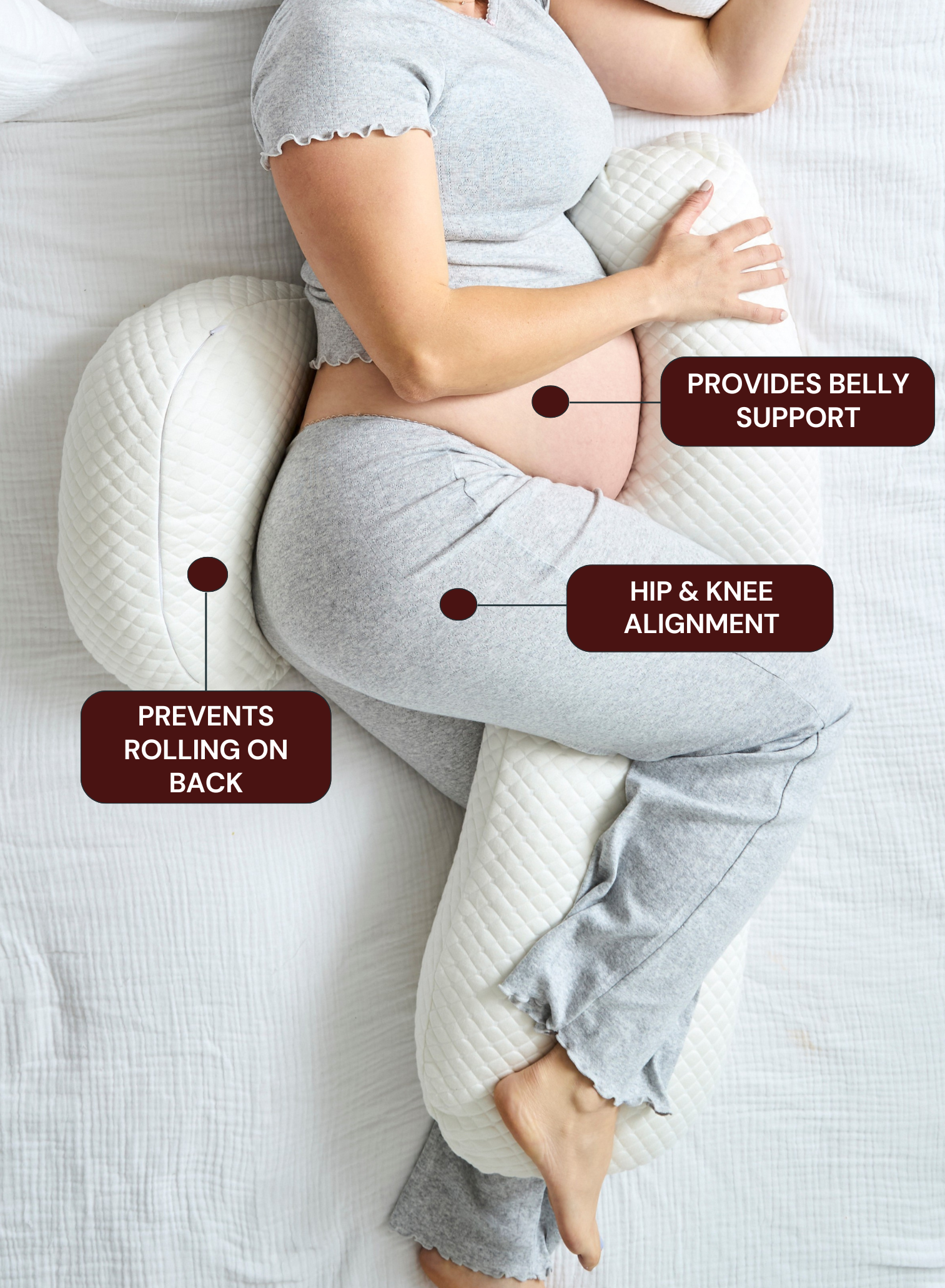 Pregnant woman using a belly support pillow on a bed