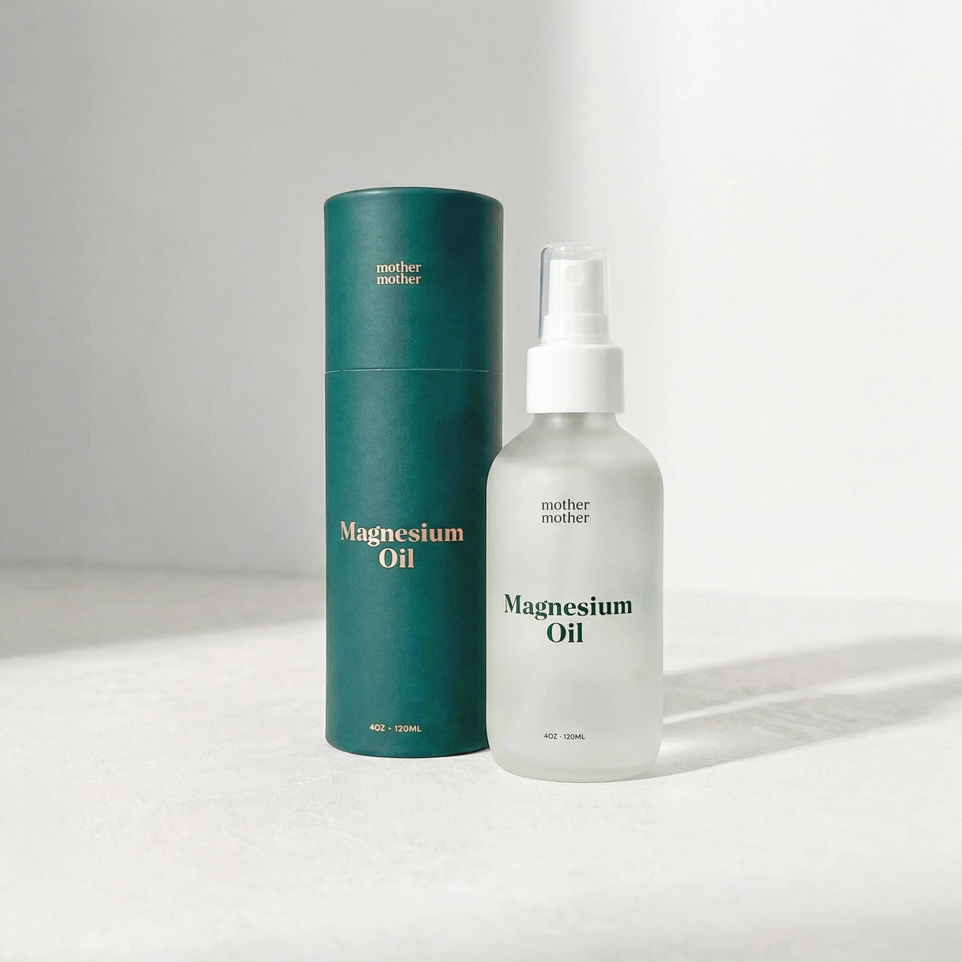 Bottle and cylindrical container of magnesium oil on a light gray background