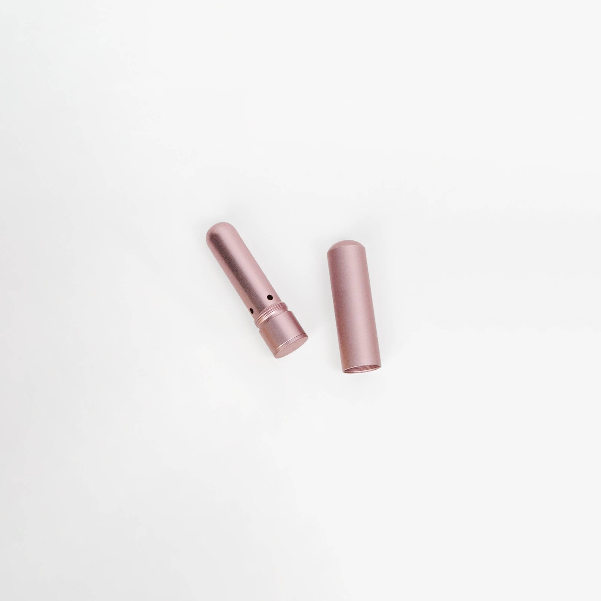 Two pink cylindrical objects on a white background