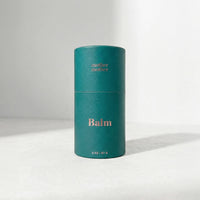 Teal cylindrical balm container with 'mother' branding on a light gray background