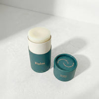 Two green containers with white lids on a light gray background