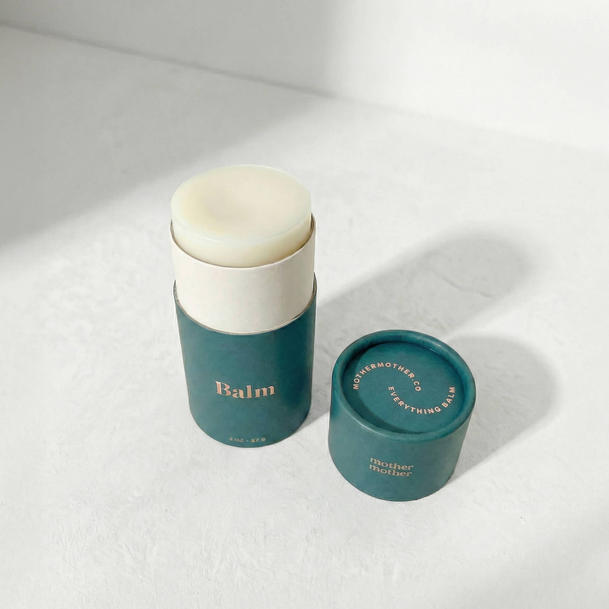 Two green containers with white lids on a light gray background