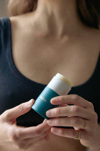 Person holding a blue and white skincare product