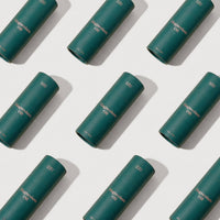 Multiple green cylindrical containers labeled 'Magnesium Oil' arranged in a pattern on a white background.
