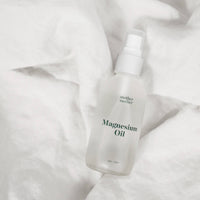 Bottle of magnesium oil on a white fabric background