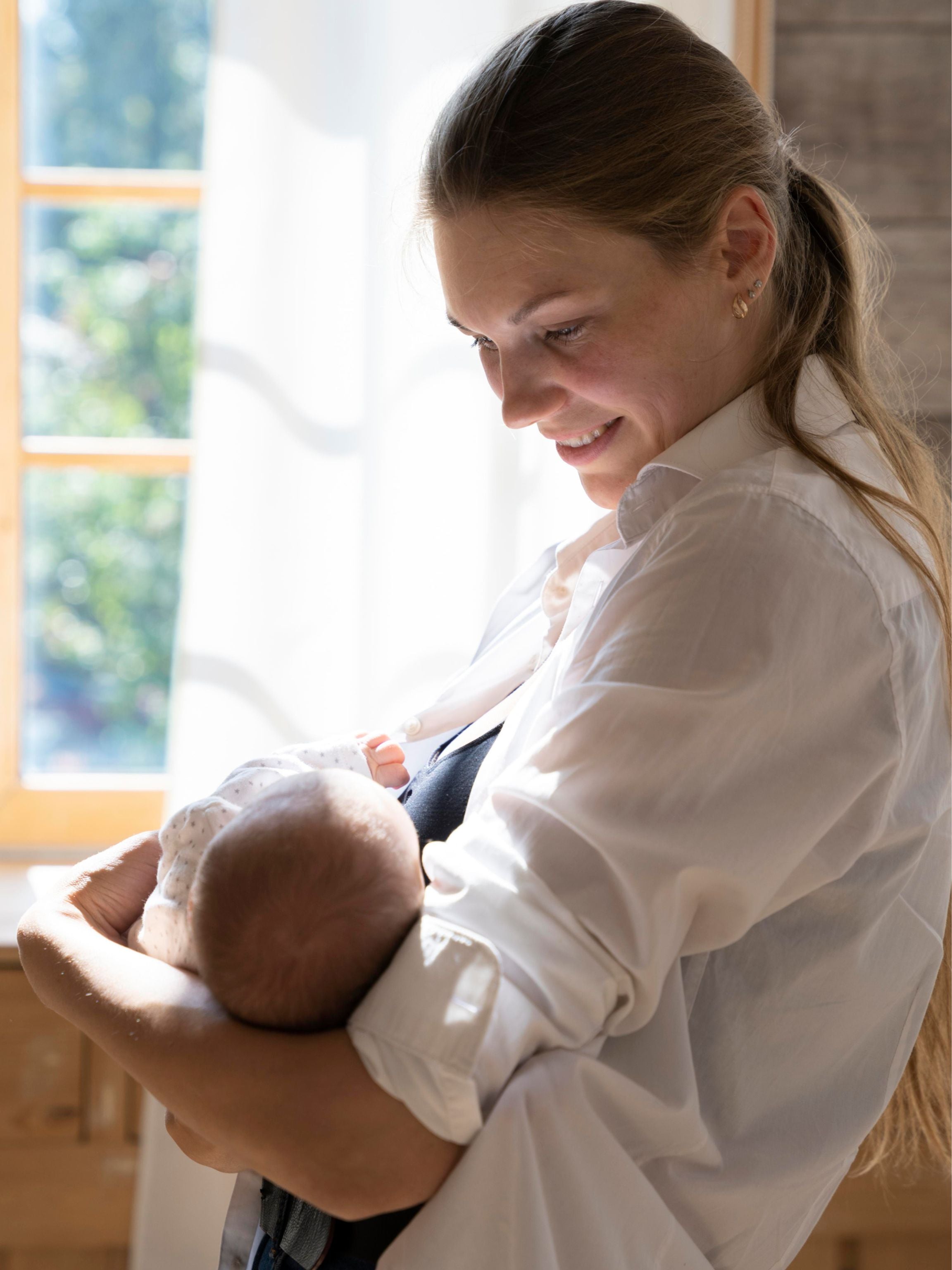 Woman breastfeeding a baby in a well-lit room