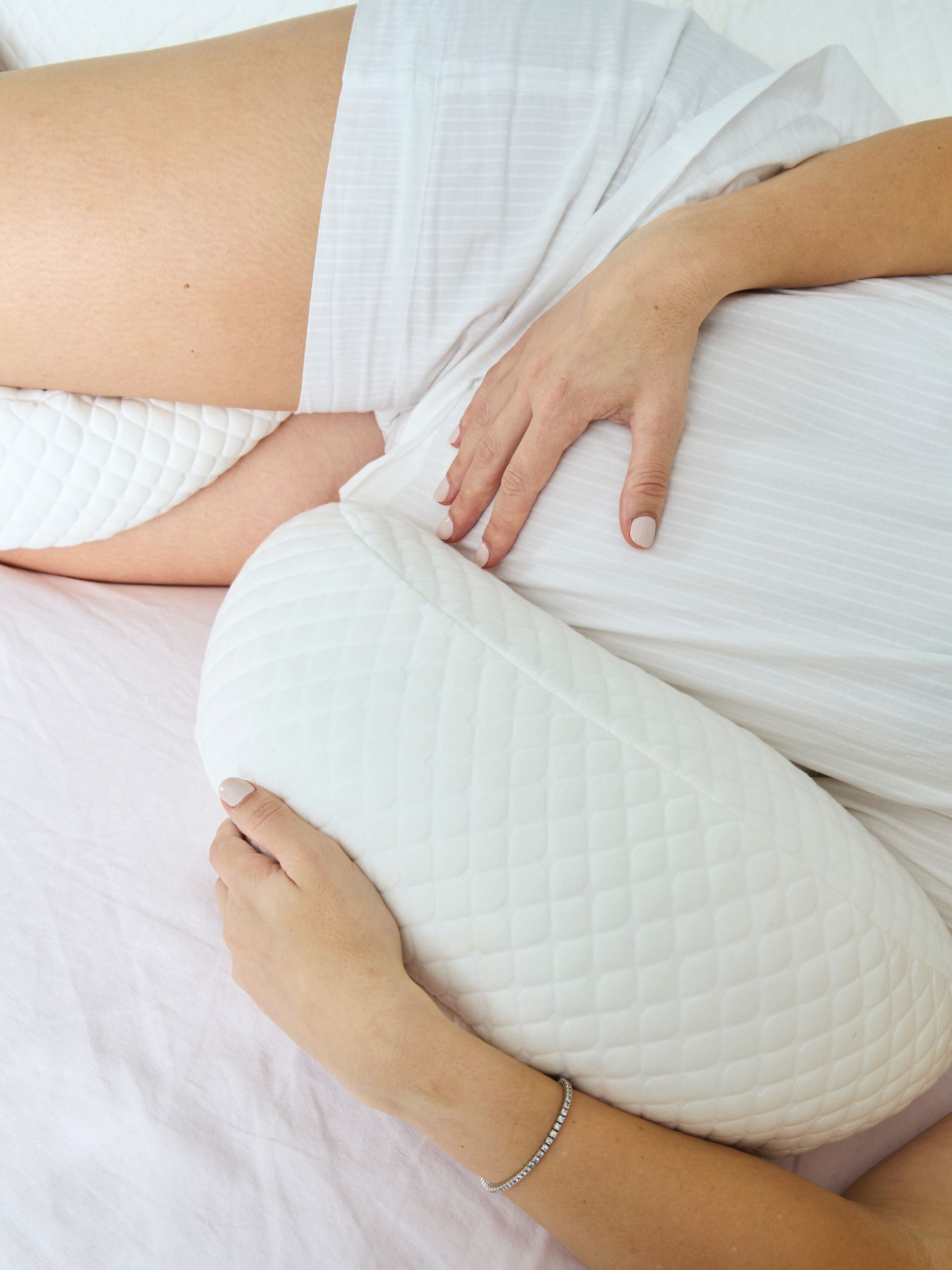 Person holding a white pillow with a blurred background