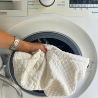 Person placing covers into a washing machine